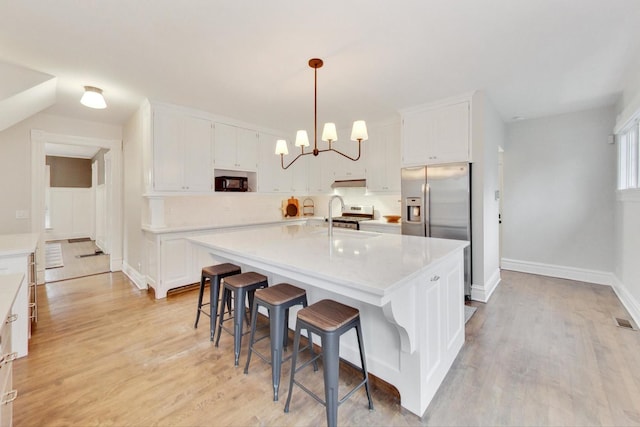 kitchen featuring light countertops, light wood-style floors, a sink, and white cabinets