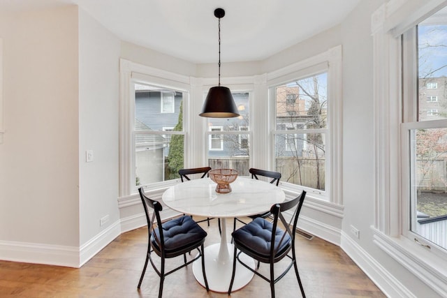 dining area with baseboards and wood finished floors
