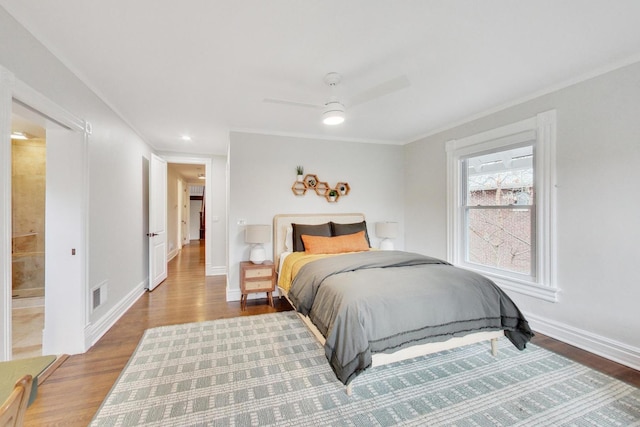 bedroom featuring crown molding, wood finished floors, baseboards, and visible vents