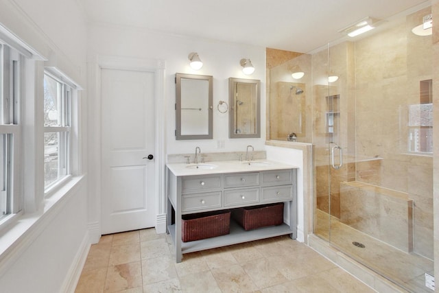 bathroom featuring double vanity, a sink, and a stall shower
