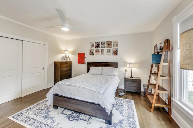 bedroom with wood finished floors, a closet, a ceiling fan, and baseboards