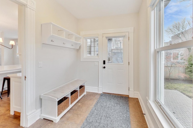 mudroom with a wealth of natural light, tile patterned flooring, and a chandelier