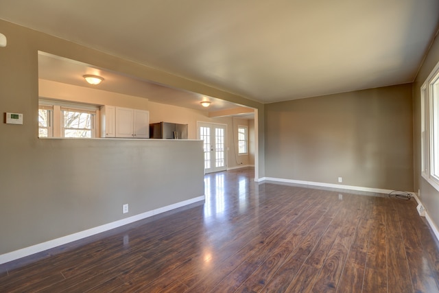 spare room with dark wood-type flooring and baseboards