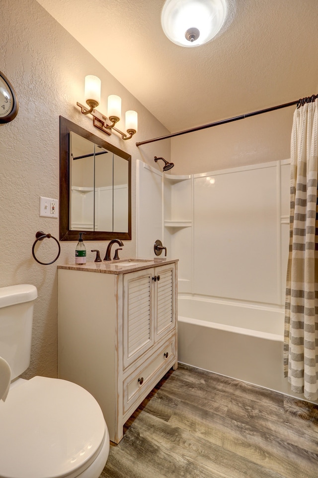 full bath featuring shower / bathtub combination with curtain, a textured wall, wood finished floors, toilet, and vanity