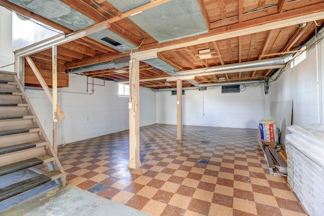 basement featuring tile patterned floors and stairway