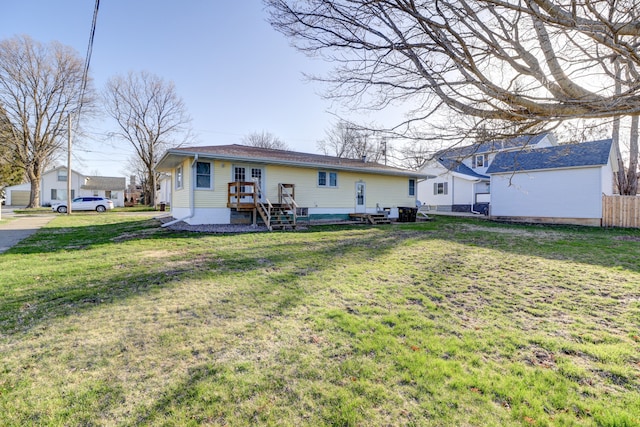 rear view of property featuring a yard and fence