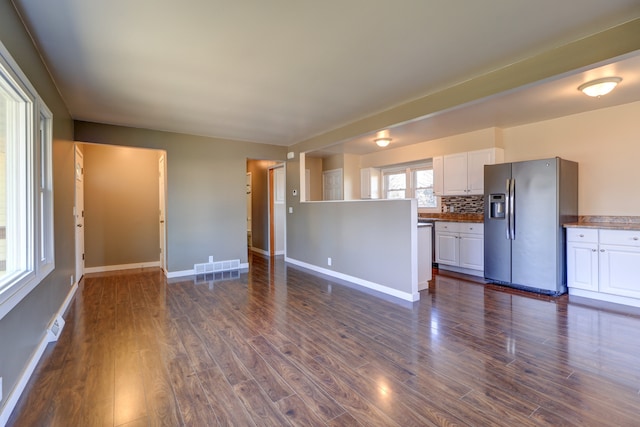 unfurnished living room featuring visible vents, baseboards, and dark wood finished floors