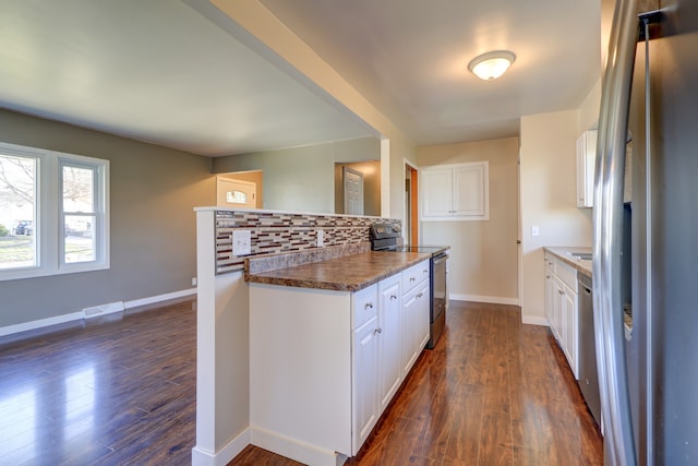 kitchen with white cabinets, stainless steel appliances, visible vents, and tasteful backsplash