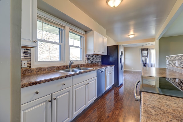 kitchen with white cabinets, a sink, appliances with stainless steel finishes, and tasteful backsplash