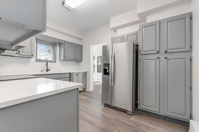 280 Westerfield Pl, Grayslake, IL 60030 - kitchen with stainless steel appliances, gray cabinets, a sink, light stone countertops, and light wood-style flooring