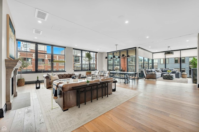 living room featuring wood-type flooring, recessed lighting, and visible vents