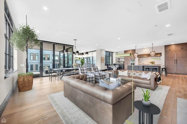 living room featuring visible vents, recessed lighting, and light wood-type flooring