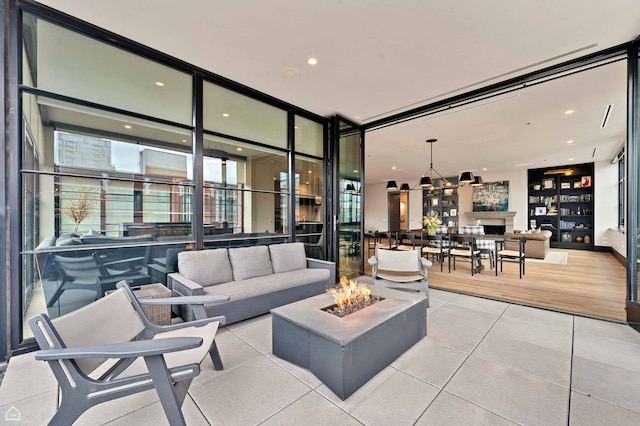 living area featuring recessed lighting, tile patterned floors, a wall of windows, and an inviting chandelier