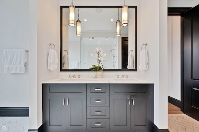 full bath featuring double vanity, a stall shower, and a sink