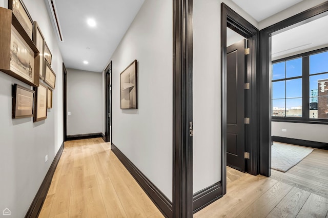 hall with recessed lighting, baseboards, and light wood finished floors