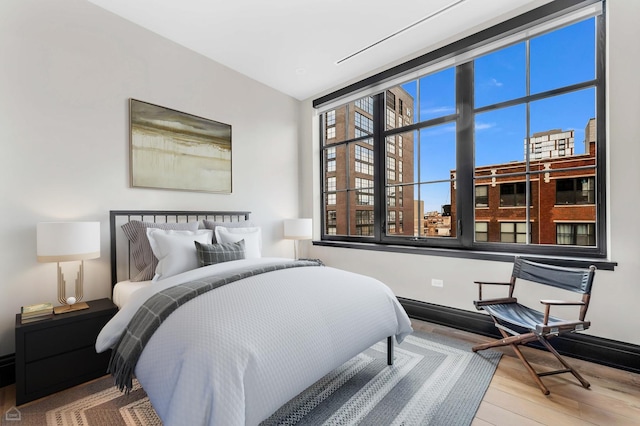 bedroom featuring baseboards and wood finished floors