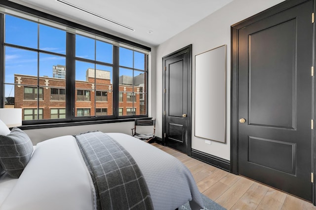 bedroom featuring baseboards and light wood-style flooring
