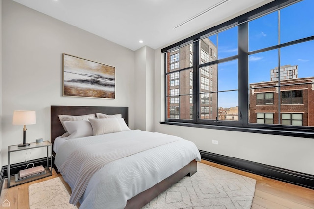 bedroom with recessed lighting and wood finished floors