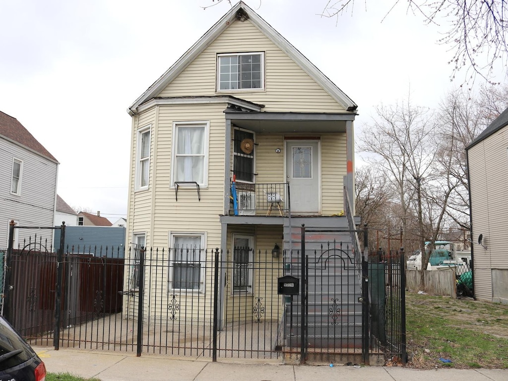 view of front of house featuring a porch, a fenced front yard, and a gate