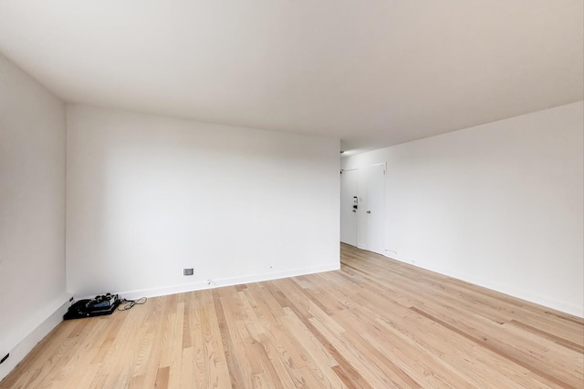 unfurnished room featuring baseboards and light wood-style floors