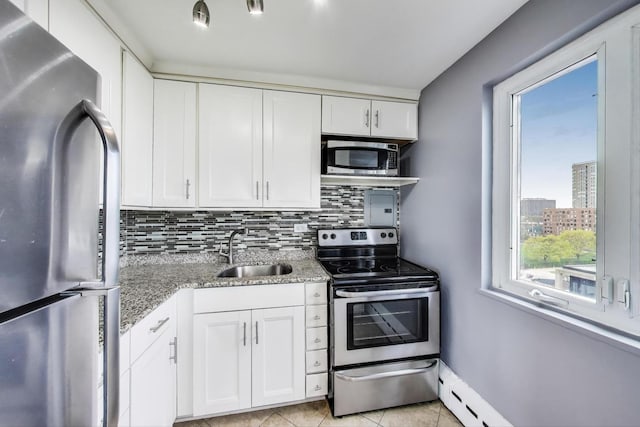 kitchen featuring tasteful backsplash, light stone countertops, a sink, stainless steel appliances, and white cabinetry