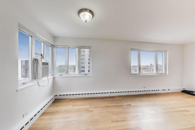 spare room with a baseboard heating unit and light wood-style flooring
