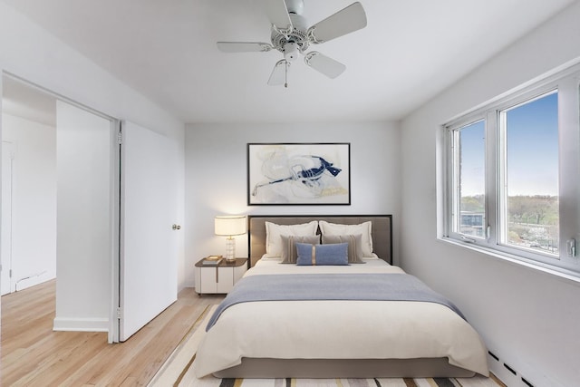 700 W Bittersweet Pl Unit 807, Chicago, IL 60613 - bedroom with a baseboard heating unit, light wood finished floors, and a ceiling fan