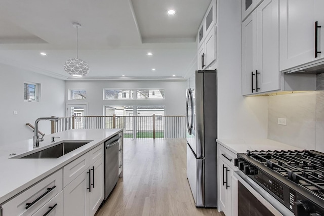 3242 N Kostner Ave, Chicago, IL 60641 - kitchen with white cabinets, a sink, light countertops, light wood-type flooring, and appliances with stainless steel finishes