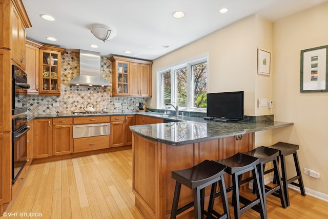 1831 Ellendale Dr, Northbrook, IL 60062 - kitchen featuring a warming drawer, wall chimney range hood, a peninsula, light wood-style floors, and stainless steel gas cooktop
