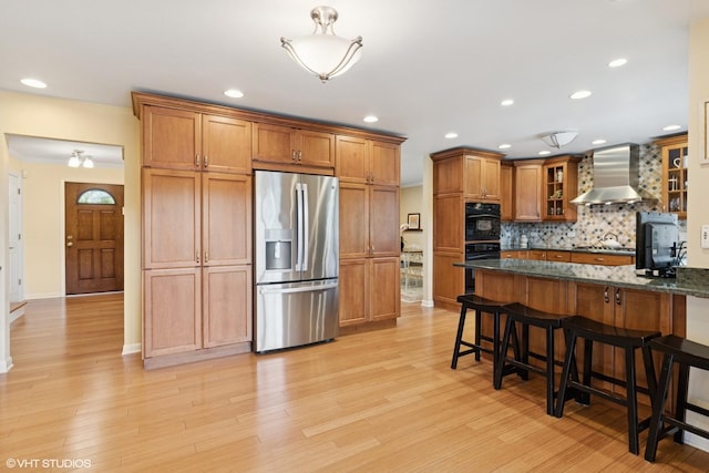 1831 Ellendale Dr, Northbrook, IL 60062 - kitchen with stainless steel appliances, wall chimney exhaust hood, a breakfast bar, brown cabinets, and decorative backsplash