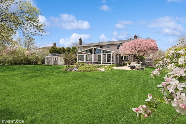 1831 Ellendale Dr, Northbrook, IL 60062 - back of house with a sunroom, a shed, a patio area, an outbuilding, and a chimney