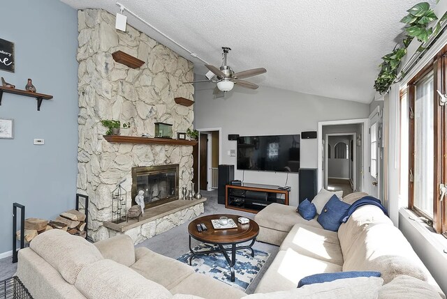 10922 Massasoit Ave, Chicago Ridge, IL 60415 - carpeted living area with a stone fireplace, a ceiling fan, vaulted ceiling, and a textured ceiling