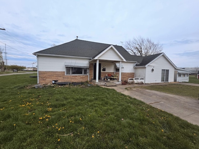 301 S Walnut St, Villa Grove, IL 61956 - view of front of property with a porch, a front yard, a shingled roof, and brick siding