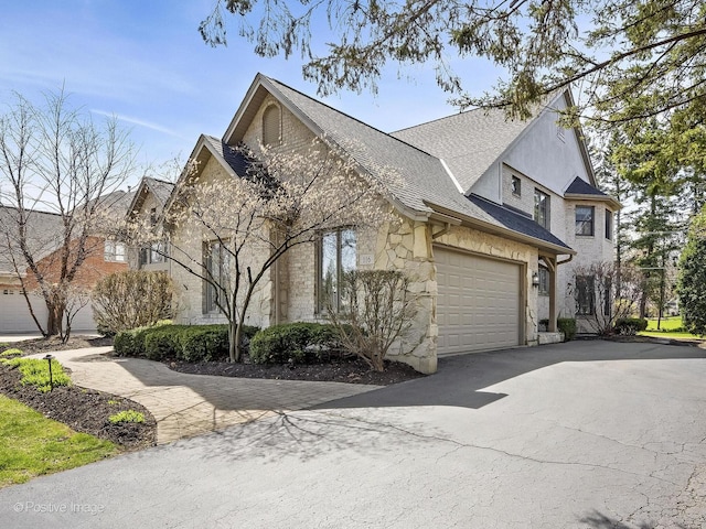 116 Springlake Ave, Hinsdale, IL 60521 - view of home's exterior with an attached garage, stone siding, and aphalt driveway