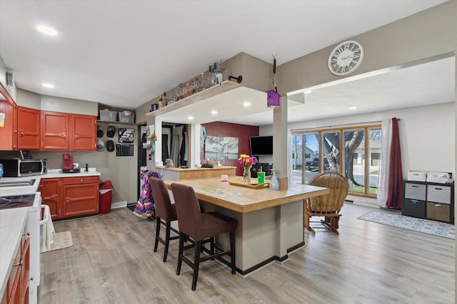 313 W S St, Pearl City, IL 61062 - kitchen featuring stainless steel microwave, recessed lighting, light wood-style flooring, a breakfast bar area, and stove