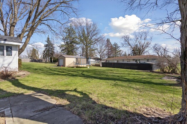 313 W S St, Pearl City, IL 61062 - view of yard featuring a trampoline, a detached garage, a shed, an outbuilding, and fence