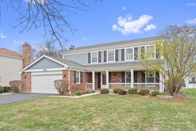 view of front of house with an attached garage, driveway, a porch, brick siding, and a front yard