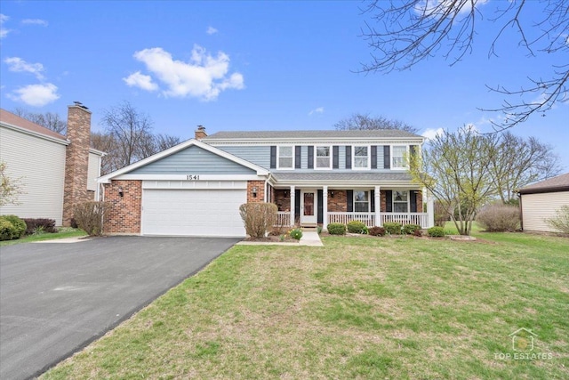 traditional-style house with a front lawn, covered porch, brick siding, an attached garage, and aphalt driveway
