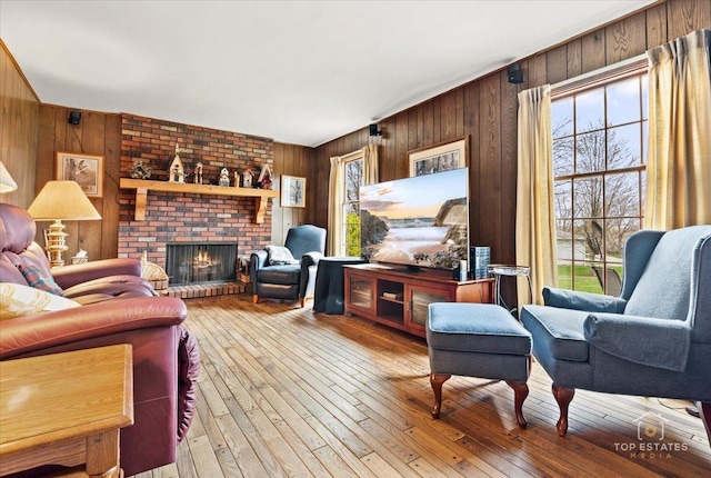 living room featuring a fireplace, hardwood / wood-style floors, and wood walls
