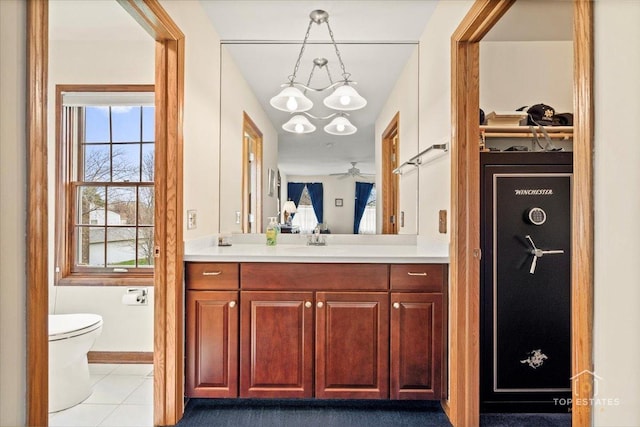 bathroom with vanity, toilet, a notable chandelier, and tile patterned flooring