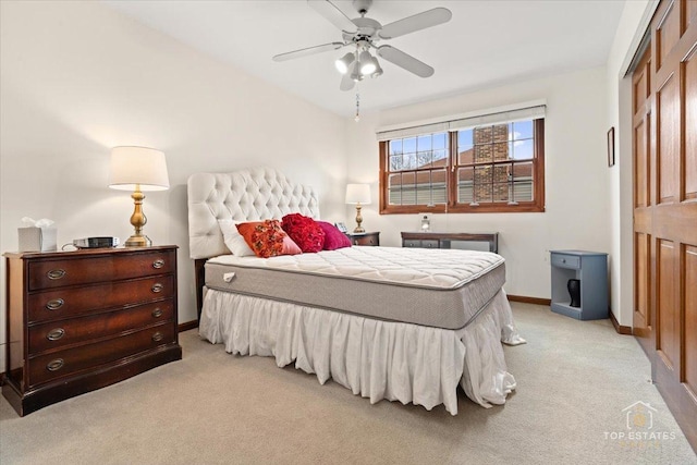 bedroom featuring light carpet, a ceiling fan, and baseboards