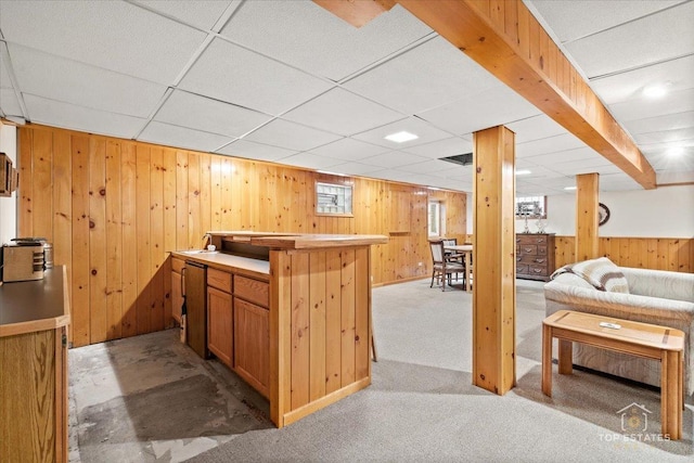 interior space featuring wood walls, carpet floors, a bar, and a paneled ceiling