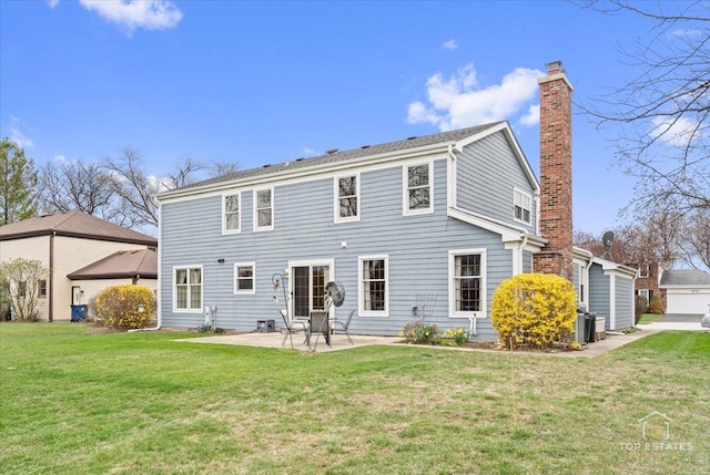 rear view of house with a chimney, a yard, and a patio