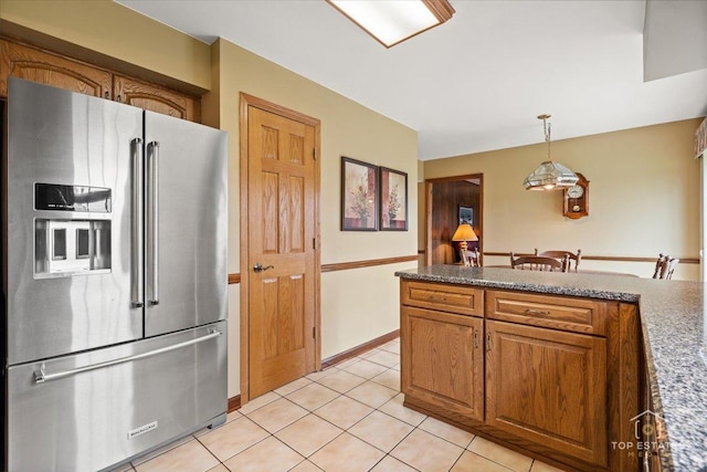 kitchen featuring decorative light fixtures, high end refrigerator, brown cabinets, and light tile patterned floors