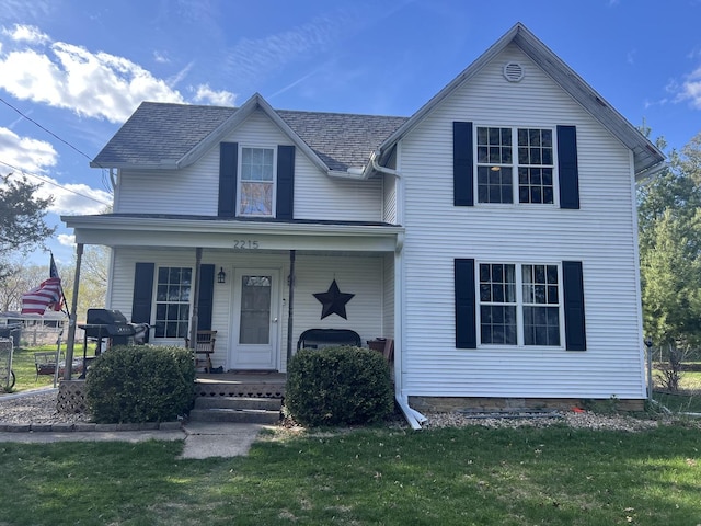 traditional-style house with a front lawn and covered porch