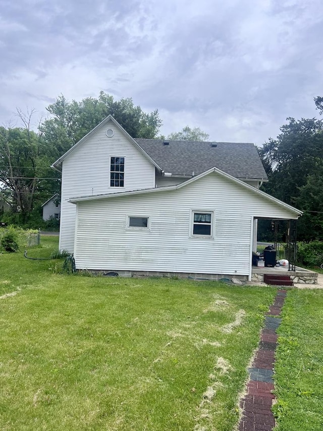2215 Deets Rd, Sterling, IL 61081 - view of property exterior featuring a lawn, roof with shingles, and a patio