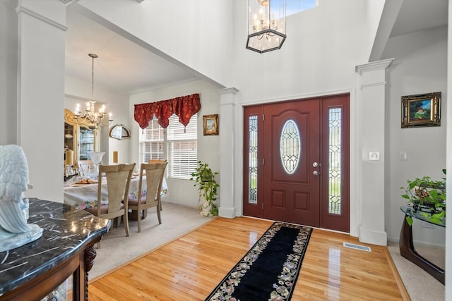 24117 Nottingham Ave, Plainfield, IL 60585 - entryway with baseboards, decorative columns, a chandelier, a towering ceiling, and wood finished floors