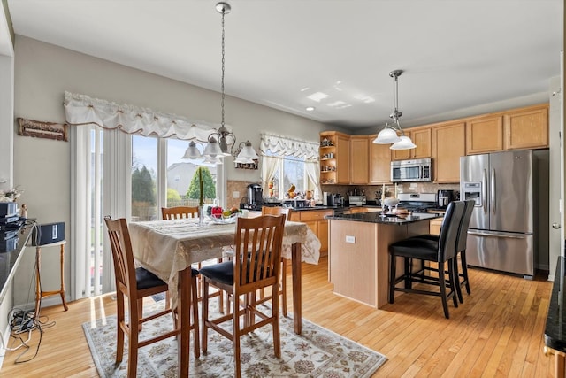 24117 Nottingham Ave, Plainfield, IL 60585 - kitchen with a center island, open shelves, light wood finished floors, stainless steel appliances, and decorative backsplash