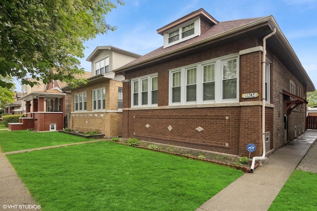 view of front of property featuring a front lawn and brick siding