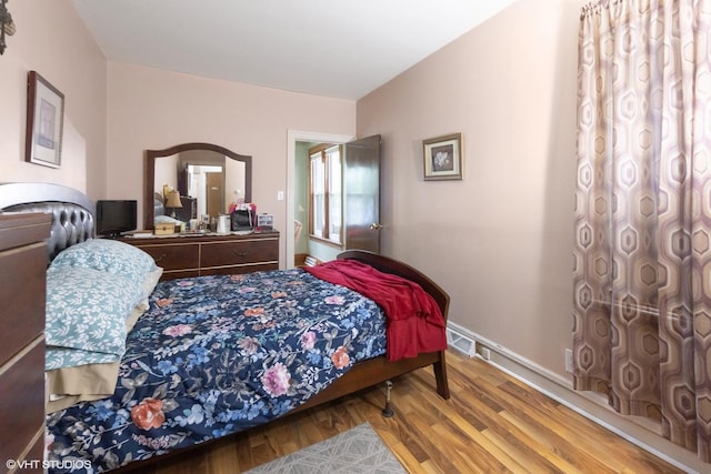 bedroom featuring visible vents and wood finished floors